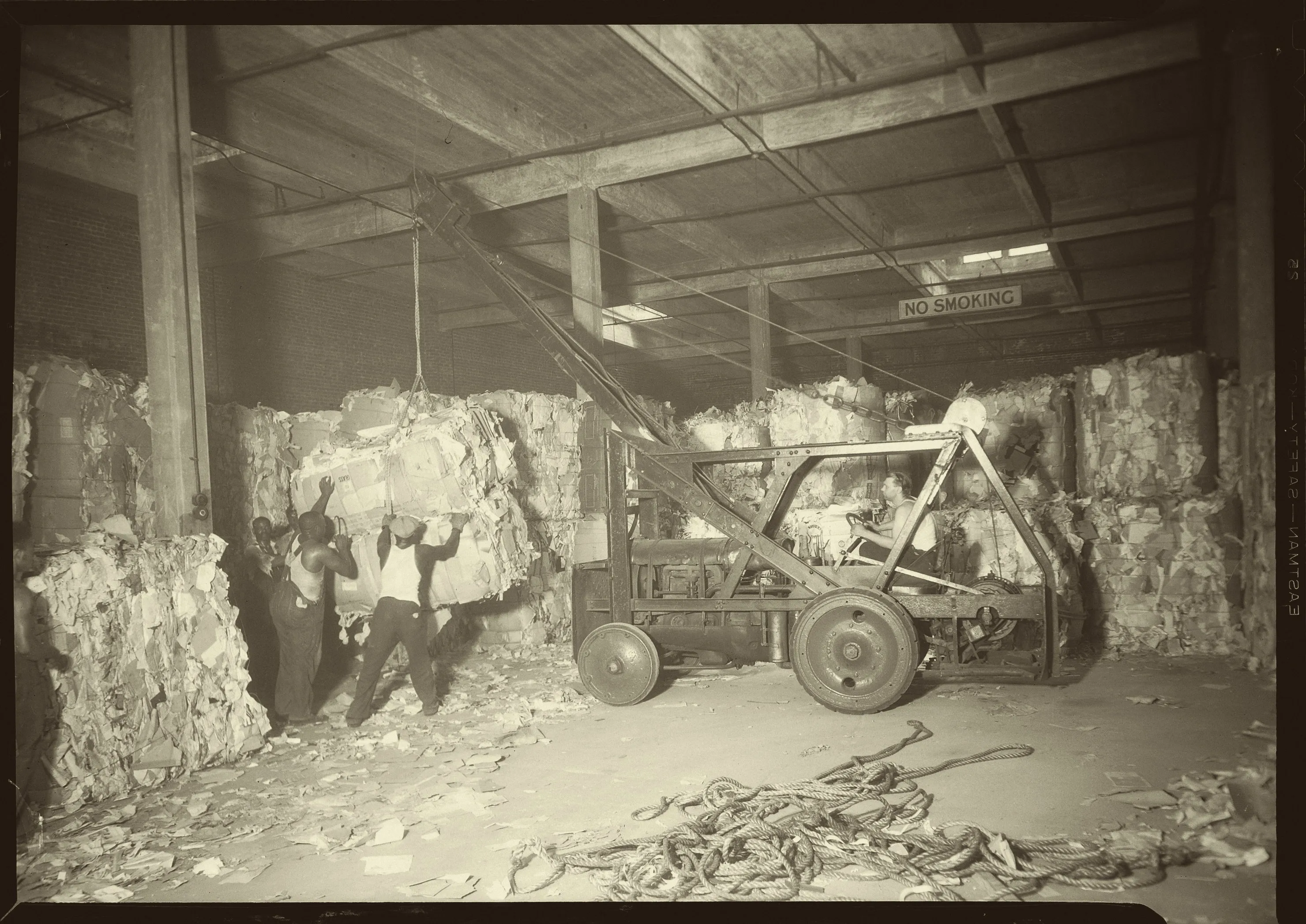 Longshoremen loading bales with a tractor crane, Bush Terminal warehouse, New York, July 1937